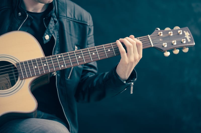 Person playing guitar as a hobby